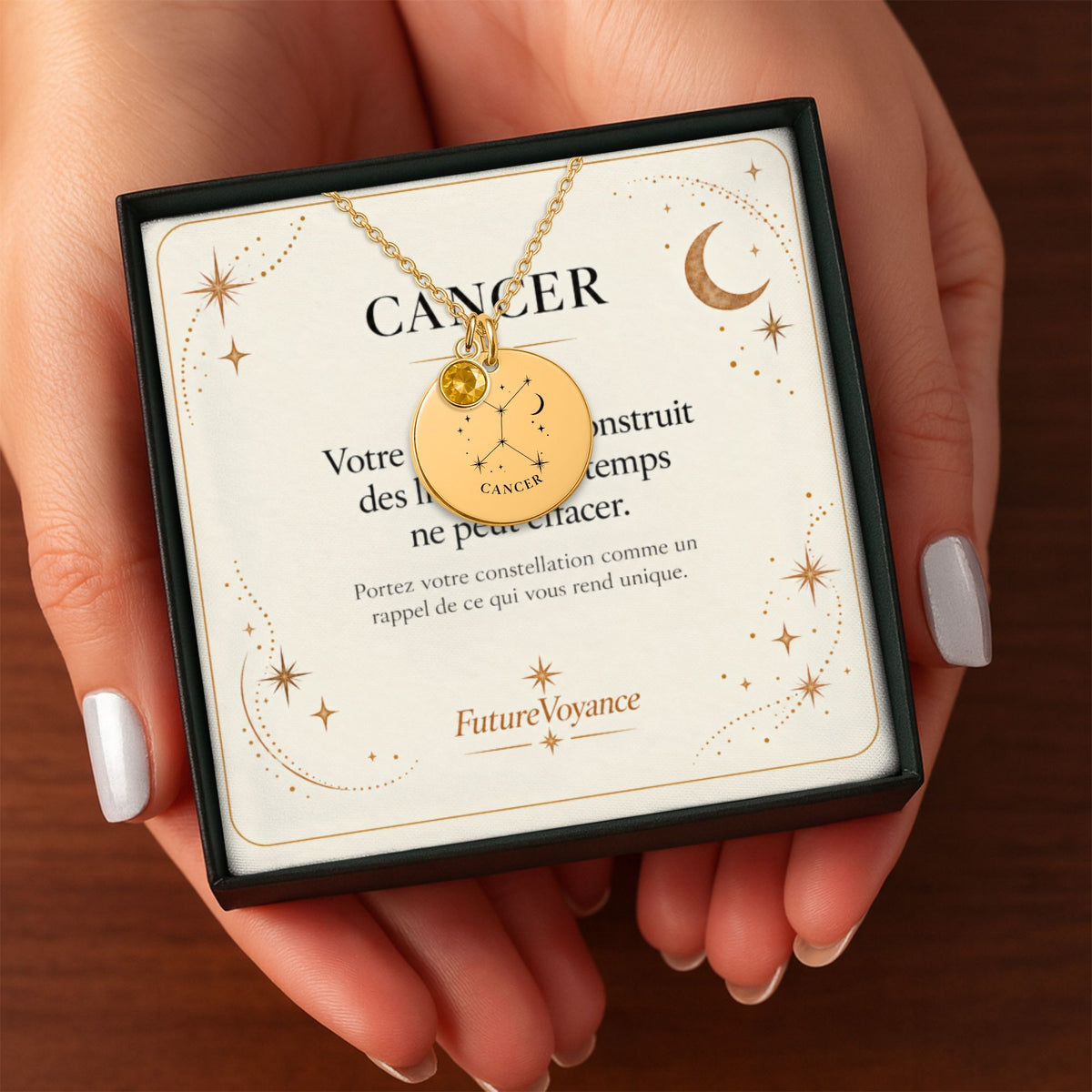 Collier constellation Cancer dans son coffret avec carte-message, tenu à la main