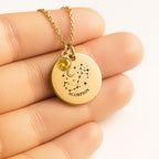 Médaille ronde gravée de la constellation Scorpion, tenue dans la main, avec pierre de naissance