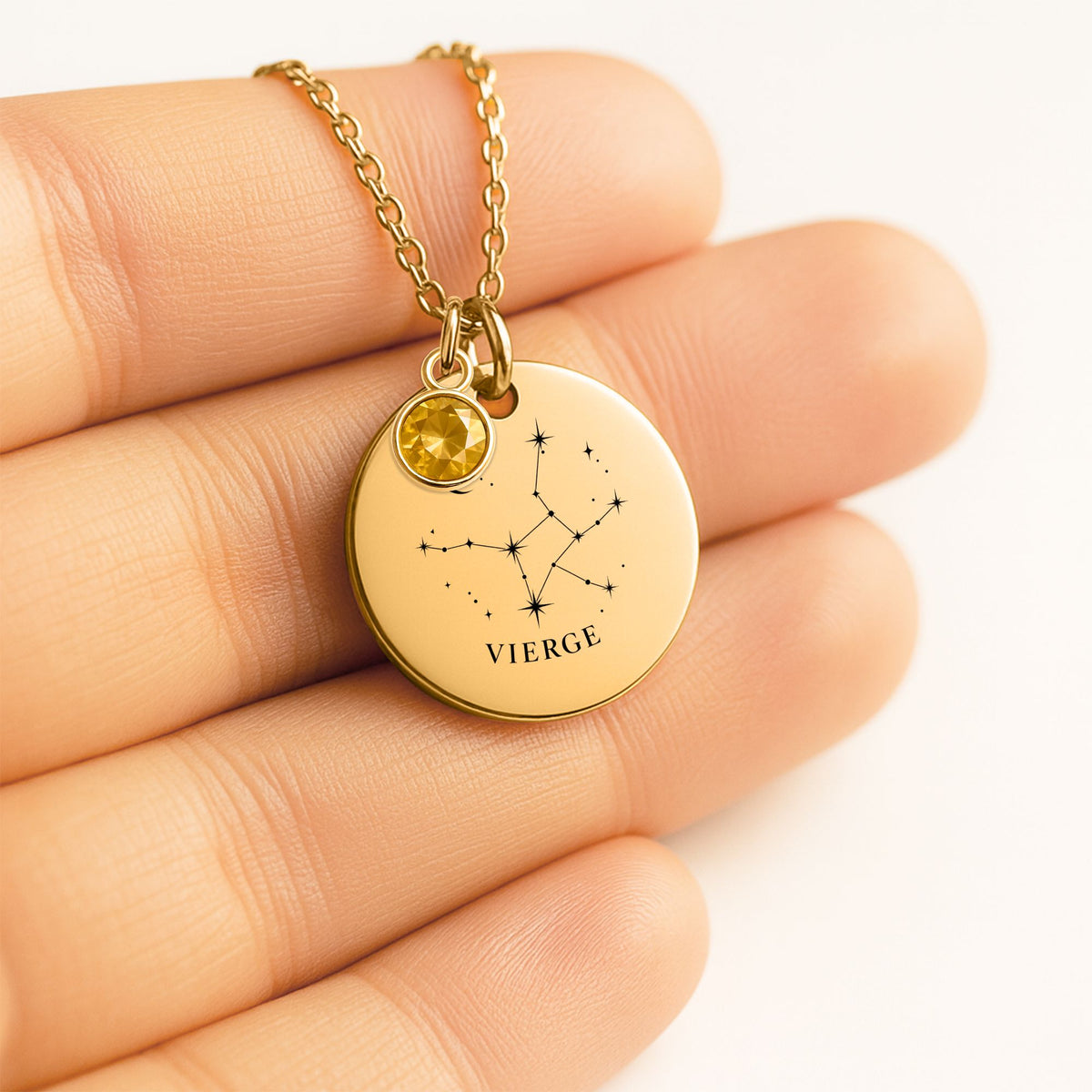 Médaille ronde gravée de la constellation Vierge, tenue dans la main, avec pierre de naissance